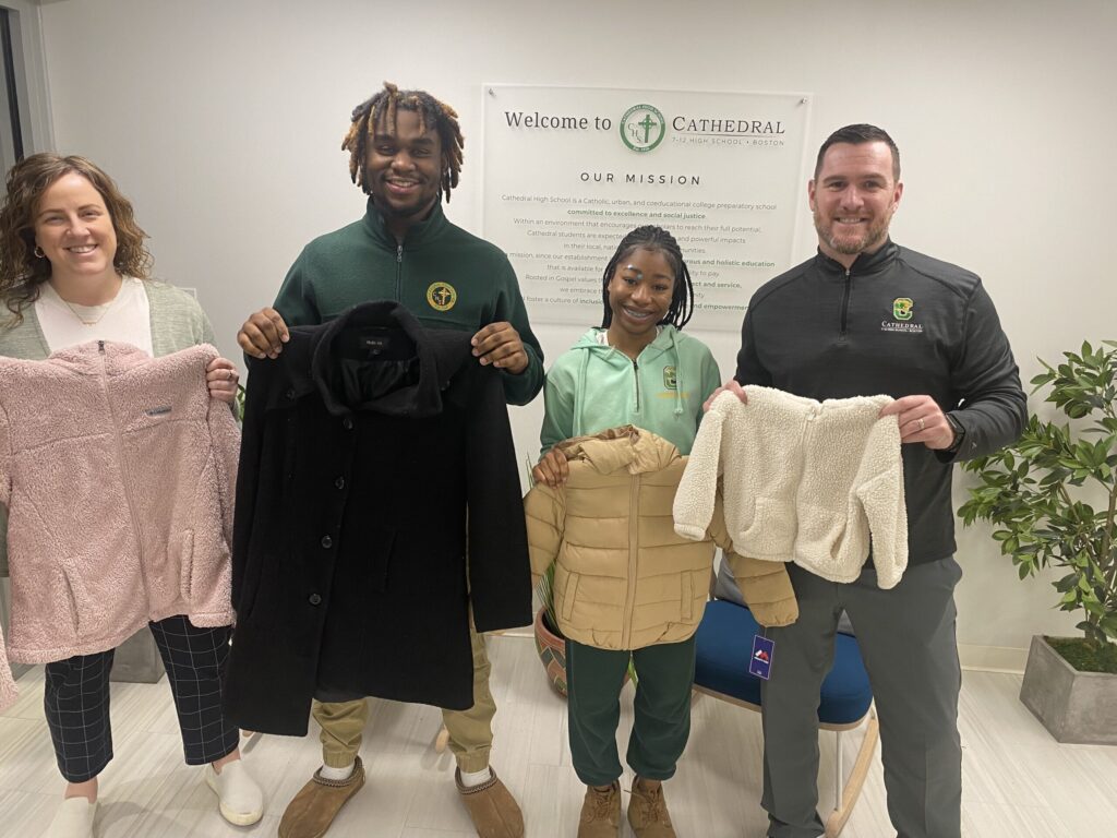 Cathedral scholar with President Dan and Lindsey Hughes, Director of Daley Center for Campus Ministry, donating warm cloths to migrants